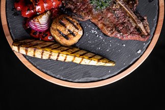 Stek t-bone serwowany na desce z łupkiem